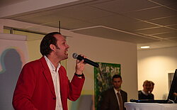 Mann in rotem Blazer mit Mikrofon 