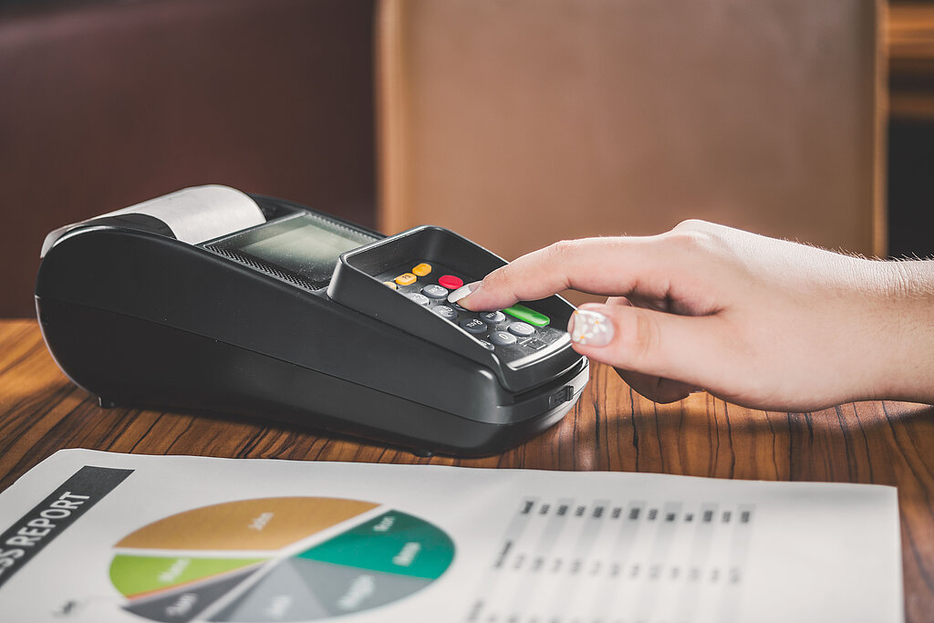 Frau tippt Code in mobilen Bankomat 