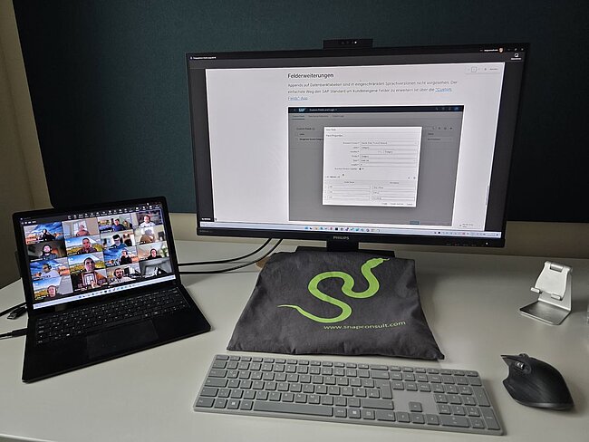 Ein Blick auf einen Laptop der an einen Monitor angeschlossen ist, am Laptop ist ein Teams Meeting zu sehen