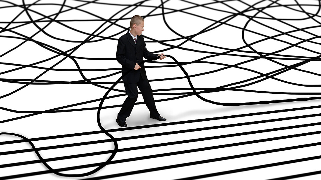 Mann im Anzug ordnet einen chaotischen Kabelsalat