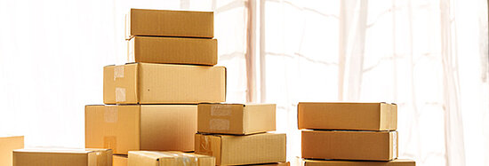 Foto, das mehrere Kartons zeigt, die sich auf einem Tisch stapeln.